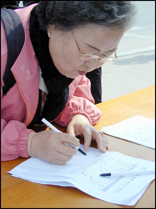 "손자 손녀를 위해" 나이 지긋한 할머니가 아이들을 위한 도서관 유치에 마음을 보태고 있다. 